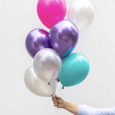 Balões coloridos em mão com camisa azul clara