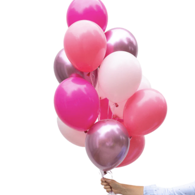 Balões rosa, branco e roxo metálico segurados por uma mão