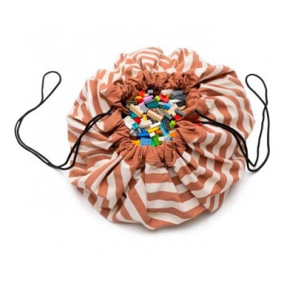 Saco de armazenamento com riscas castanhas e brancas e cordões pretos com peças de construção coloridas dentro