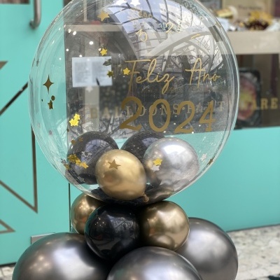 Balão transparente decorativo com texto 'Feliz Ano 2024' e balões dourados, prateados e pretos