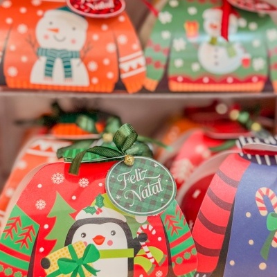 Caixas de presente de Natal em forma de camisolas coloridas com bonecos de neve e pinguins.
