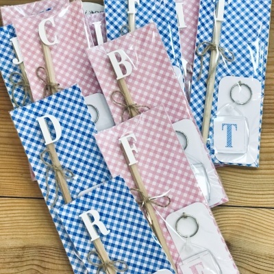 Conjunto de marcadores de livros em madeira com letras e porta-chaves com letras em embalagens com padrão xadrez azul e rosa