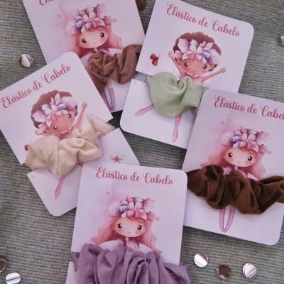 Cinco elásticos de cabelo em várias cores em cartões com desenho de bailarina e texto 'Elástico de Cabelo'.