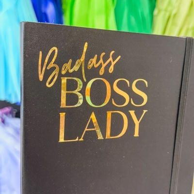 Caderno preto com texto 'Badass BOSS LADY' em dourado
