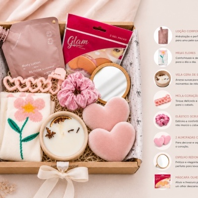 Caixa de presente com vários produtos de cuidado pessoal e acessórios em tons rosa e branco
