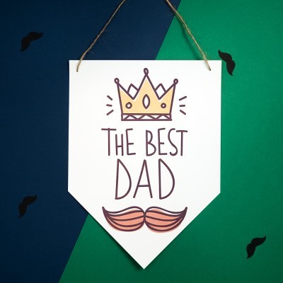 Pendente branco com coroa, texto 'THE BEST DAD' e bigode, fundo azul e verde