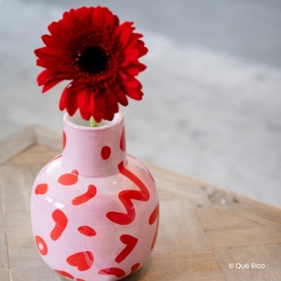 Vaso de cerâmica rosa com padrão vermelho e flor vermelha