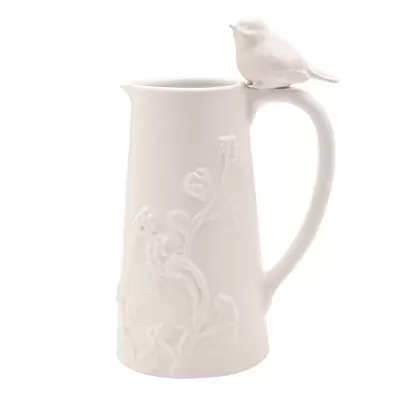 Jarro cerâmico branco com padrão floral e pássaro no punho.