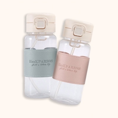 Duas garrafas de água transparentes com suportes em couro azul e rosa