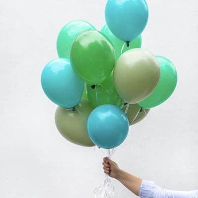 Balões coloridos segurados por mãos contra fundo branco