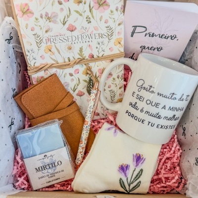 Conjunto de presentes contendo caneca com texto, caderno floral, caneta, sabonete e almofada bordada
