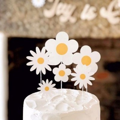 Bolo branco decorado com flores brancas com centros amarelos no topo