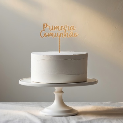 Bolo branco com topo dourado 'Primeira Comunhão' em suporte branco