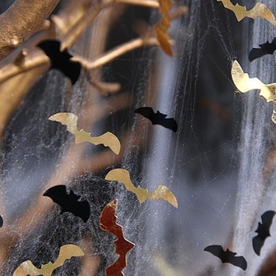 Decoração de Halloween com morcegos dourados e pretos e teia de aranha