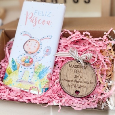 Barra de chocolate e medalha de madeira em embalagem com confetes de papel rosa