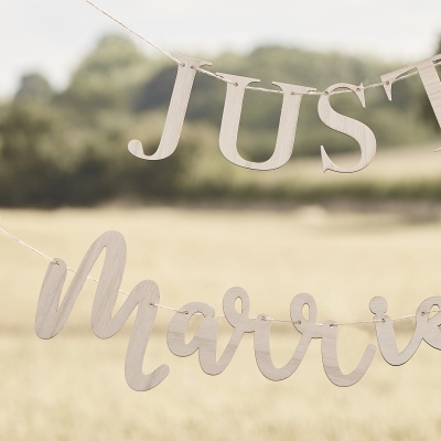 Letras em madeira penduradas ao ar livre com texto 'JUST Married'