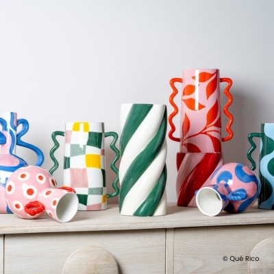 vasos cerâmicos coloridos com padrões variados sobre superfície de madeira