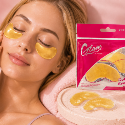 Máscaras oculares de gel douradas Collagen Eye Mask da Glam of Sweden em embalagem rosa com mulher a usar as máscaras debaixo dos olhos