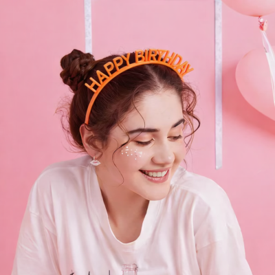 Diadema laranja com texto HAPPY BIRTHDAY em cabeça de mulher com camisola branca