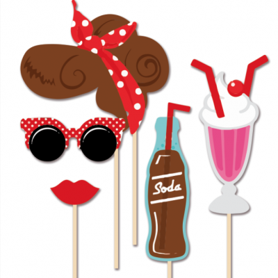 Adereços de festa com tema vintage em palitos, incluindo cabelo, óculos, lábios, garrafa de refrigerante e copo com chantilly.