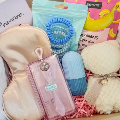 Vários produtos de cuidado pessoal e beleza organizados numa caixa com papel cor-de-rosa.