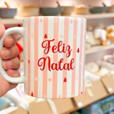 Caneca com riscas cor de salmão e branco e texto 'Feliz Natal'
