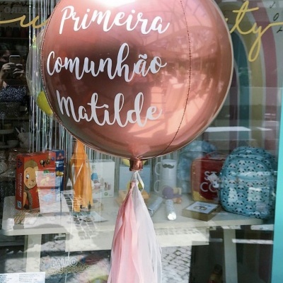 Balão rosa metálico com texto de comunhão em montra