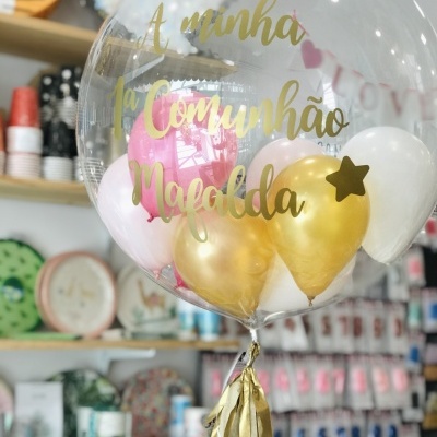 Balão transparente com balões interiores rosa, dourado e branco e texto dourado