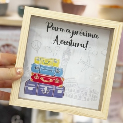 Quadrado de madeira com ilustração de malas coloridas e texto para a próxima aventura