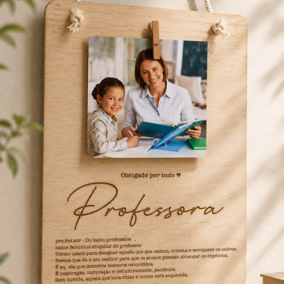 Placa de madeira clara pendurada com corda, com foto e texto gravado sobre professora.