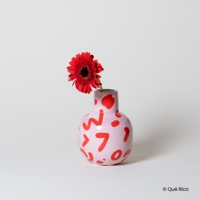 Vaso rosa com desenhos vermelhos e flor vermelha