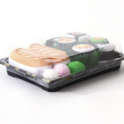 Embalagem plástica transparente com sushi de tecido e bolas coloridas