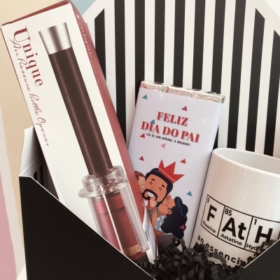 Conjunto de presente com saca-rolhas, barra de chocolate e caneca dentro de caixa preta