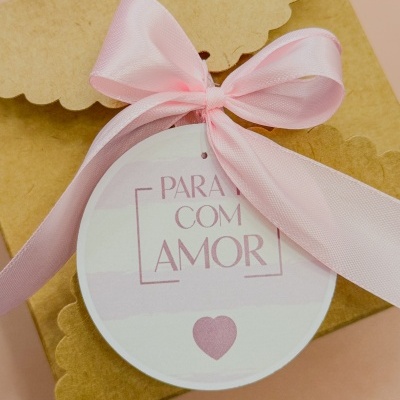 Caixa de presente em papel castanho com fita rosa e etiqueta redonda com texto 'PARA TI COM AMOR'