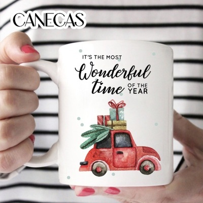 Caneca branca com carro vermelho e presentes, texto em inglês, mãos femininas com unhas rosa e fundo às riscas
