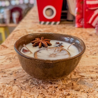 Vela aromática em tigela cerâmica com anis-estrelado e laranja seca