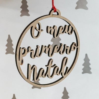 Enfeite de Natal redondo em madeira com texto 'O meu primeiro Natal'