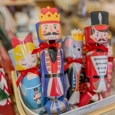 Figuras coloridas de papel em forma de personagens natalinas com fitas vermelhas