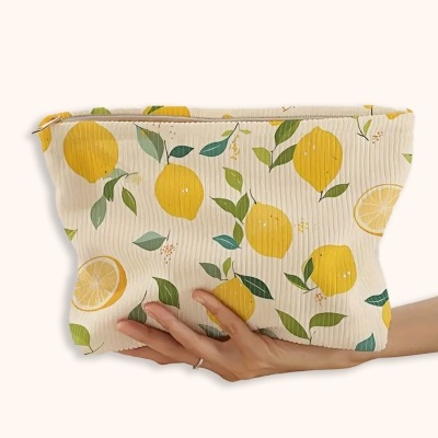 Bolsa de tecido creme com padrão de limões e folhas verdes