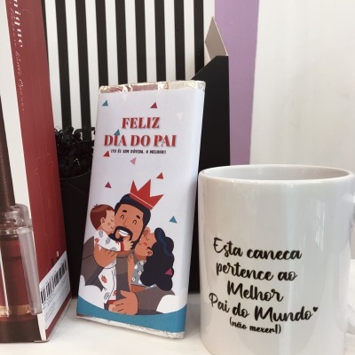 Barra de chocolate e caneca branca com mensagens do Dia do Pai num ambiente interior