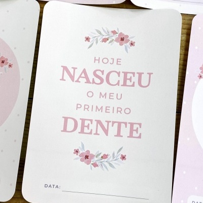 Cartão para registo do primeiro dente do bebé com texto e motivos florais em rosa