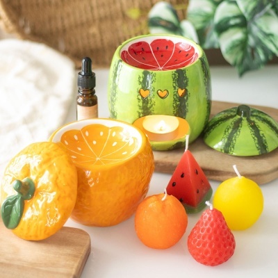 Velas em forma de frutas e porta-velas decorativos de cerâmica com tema de frutas.