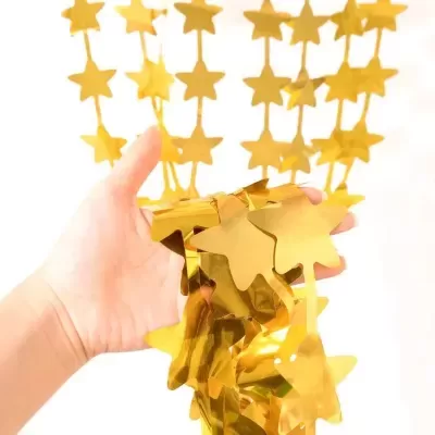 Corrente decorativa de estrelas douradas em mãos sobre fundo claro