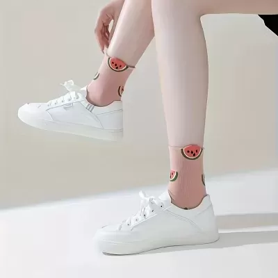 Meias cor-de-rosa com padrão de melancia usadas com ténis brancos.