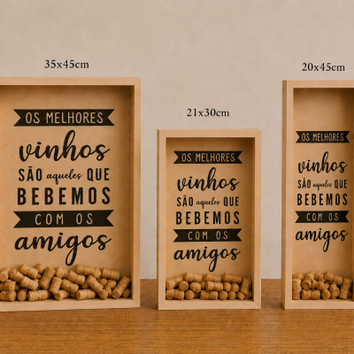 Três quadros para rolhas de vinho com frases em português e diferentes tamanhos sobre uma mesa com decoração.