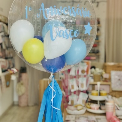 Balão transparente com balões pequenos coloridos e texto azul em loja