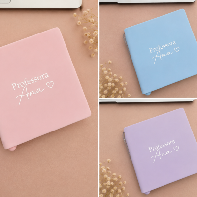 Capas de agendas rosa, azul e lilás com texto branco Professora Ana e coração, em superfície bege com flores secas