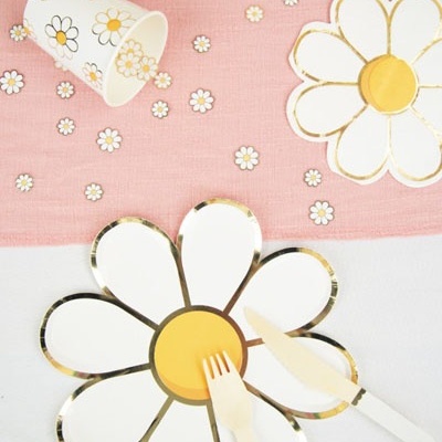 Conjunto de festa com prato, talheres, copo e toalha decorados com flores margariadas.