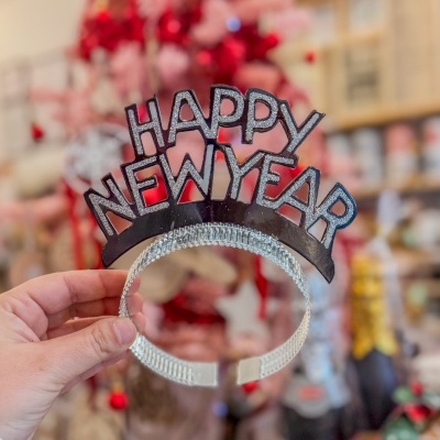 Aro de cabeça preto com brilho prateado escrito HAPPY NEW YEAR e faixa prateada