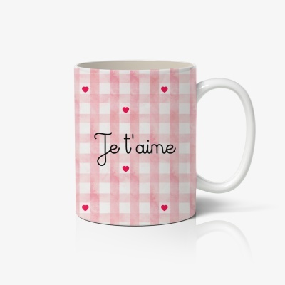 Caneca branca com padrão xadrez rosa e texto 'Je t'aime' e corações vermelhos
